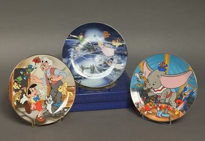 trois assiettes avec des personnages de dessins animés posées sur une boîte bleue