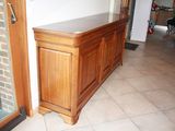 a wooden cabinet in the middle of a tiled floor