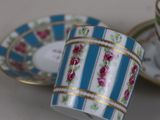 two tea cups and saucers sitting on a table