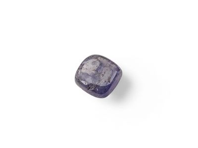 un gros plan d'un saphir violet posé sur une surface blanche