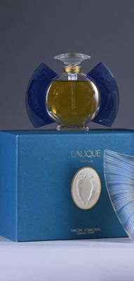 a bottle of perfume sitting on top of a blue box
