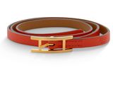 un gros plan d'une ceinture avec une boucle dorée sur fond blanc