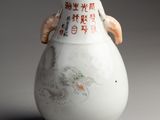 a white vase with asian writing on it on a gray surface