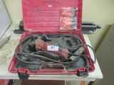 une boîte à outils rouge contenant des outils, posée sur une table