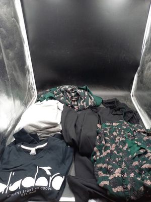 un tas de vêtements posé dans une boîte en métal posée par terre