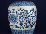 blue and white vase with flowers and birds on it against a dark background