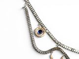 a silver necklace with a blue eye on it