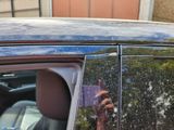 a man taking a picture of himself in the reflection of a car window