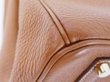 close up of a brown leather purse with a zipper on the inside