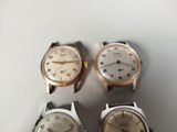 three different types of watches sitting on top of a white surface