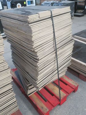 Plusieurs piles de bois sont posées sur une palette dans un entrepôt