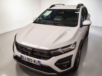 Un SUV blanc est garé dans une pièce blanche équipée d'une galerie de toit noire.