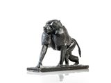 statue représentant un babouin assis sur un morceau de bois posé sur une surface blanche