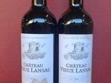 two bottles of wine sitting on top of a table next to each other