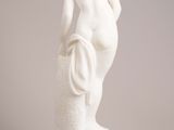 white marble statue of a woman holding a basket on a pedestal
