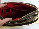 a hand that is holding a purse on a table