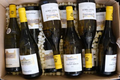 bottles of wine in a cardboard box filled with balls of white wine