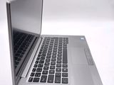 a silver laptop with a black keyboard on a white surface