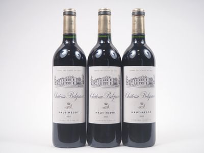 trois bouteilles de vin rouge posées l'une à côté de l'autre sur une surface blanche