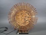 une sculpture en bois représentant un tournesol, posée sur un socle