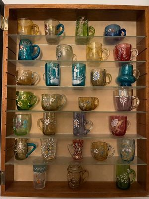 many cups and mugs on the shelves in the cabinet