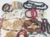 many different types of necklaces and bracelets on the table