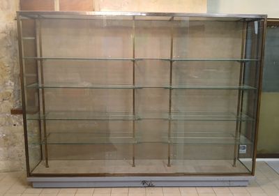a display case with glass shelves in the middle of a room