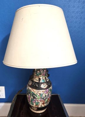 une lampe posée sur une table, avec un mur bleu en arrière-plan