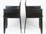 pair of black leather chairs with metal legs and backrests