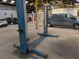 une voiture garée dans un garage équipé de deux ponts élévateurs