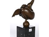 une image représentant une sculpture en bronze d'un oiseau posée sur un socle en marbre