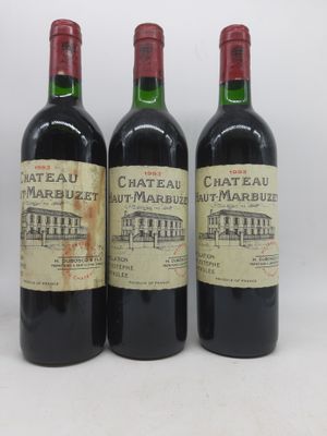 trois bouteilles de vin sont alignées sur une surface blanche