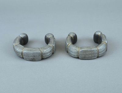 paire de boucles d'oreilles créoles en métal argenté ornées de perles noires sur fond gris