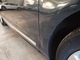 a close up of a car door with a car in the background