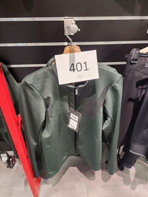 trois vestes suspendues à un portant dans un magasin