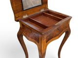 an old wooden table with a glass top and a drawer on it