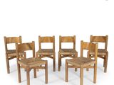 four wooden chairs and a stool are arranged in a circle