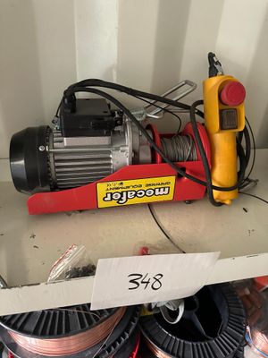 une photo montrant une boîte de fils électriques et un ventilateur posés sur une étagère