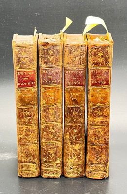 three old books are stacked on top of each other on a table