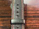the strap is black with red stitching on the side of the watch