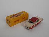 a red and white toy car next to a yellow box