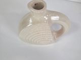 a small white vase sitting on top of a table