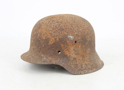 an old rusty helmet with holes on the side of it