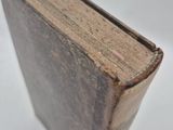 an old book sitting on top of a white surface