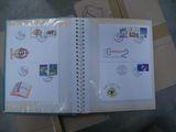 an open book with stamps on it sitting on top of a pile of boxes