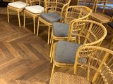 de nombreuses chaises et tables dans une pièce au sol en parquet