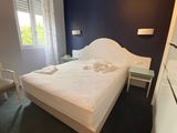 a white bed sitting in a bedroom next to a window