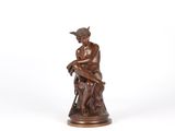 a bronze statue of a man sitting on a rock
