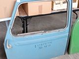 une voiture bleue dans un garage, avec des cartons par terre