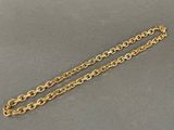 a close up of a gold chain on a gray surface